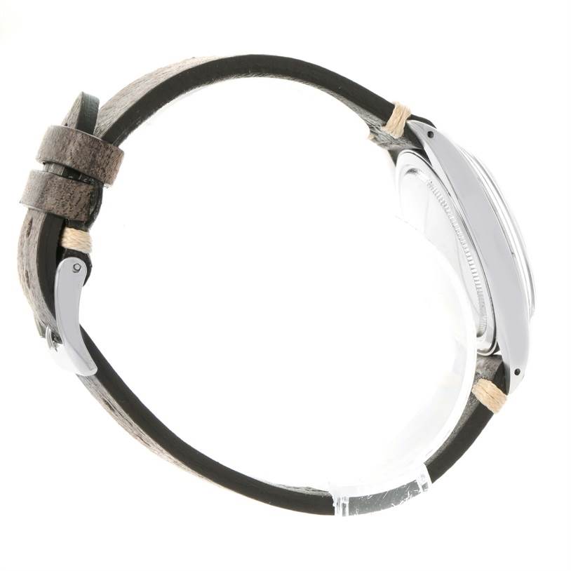 The image shows a side view of a Vintage Collection Rolex watch, highlighting the case, bezel, and leather strap.