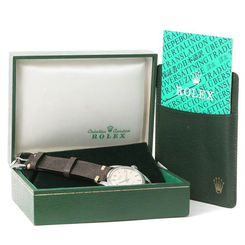 The image shows the Rolex Vintage Collection 6426 Men's Stainless Steel Silver Dial 6426 Men's Stainless Steel Silver Dial watch and accessories from a front angle inside an open green box with documents on the side.