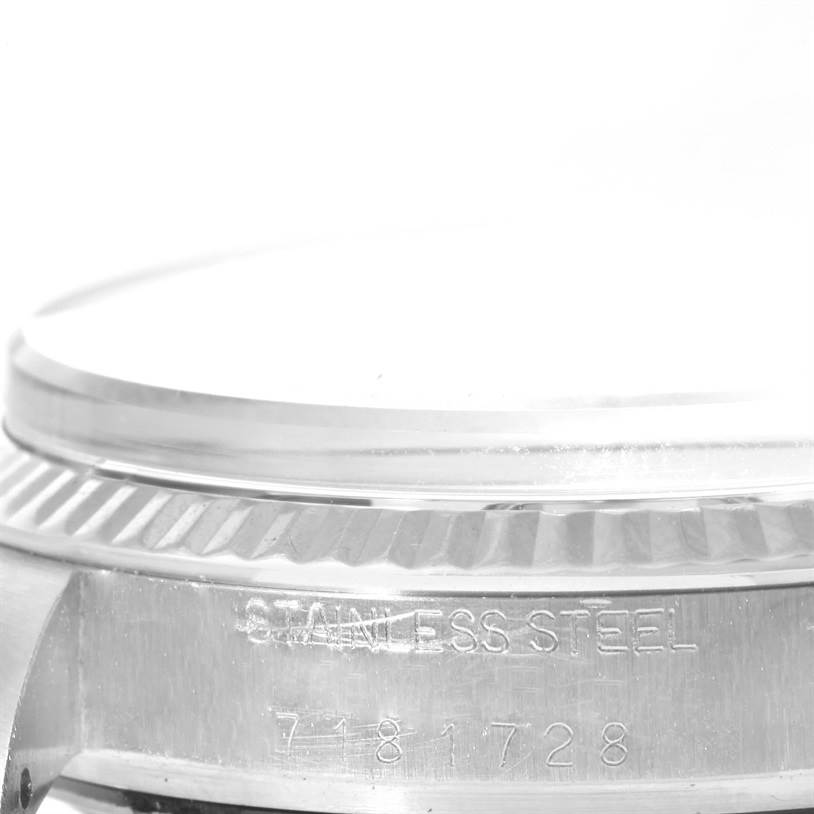 The image shows a close-up of the side case and bezel of a Vintage Collection Rolex watch, highlighting the stainless steel material and serial number.