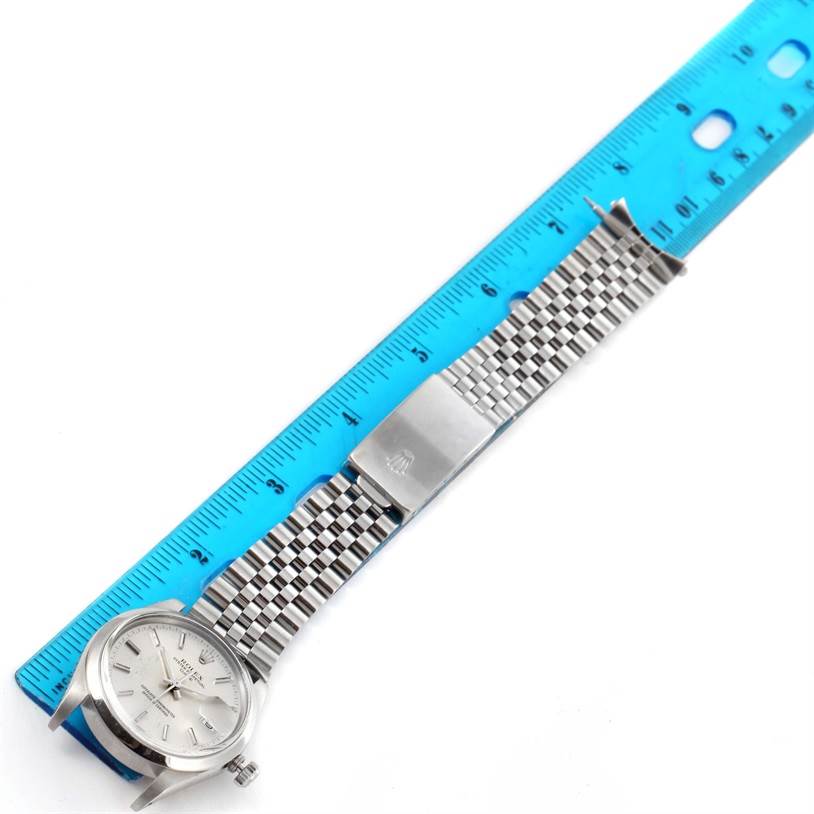 The image shows a Rolex Vintage Collection 15000 Men's Stainless Steel Silver Dial 15000 Men's Stainless Steel Silver Dial watch laid flat alongside a blue ruler, displaying the watch face and bracelet with clasp.