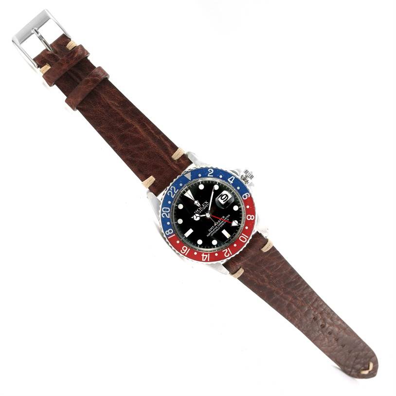 The image shows a full top-down view of a Rolex Vintage Collection 1675 Men's Stainless Steel Black Dial 1675 Men's Stainless Steel Black Dial model watch with its dark brown leather strap fully extended.