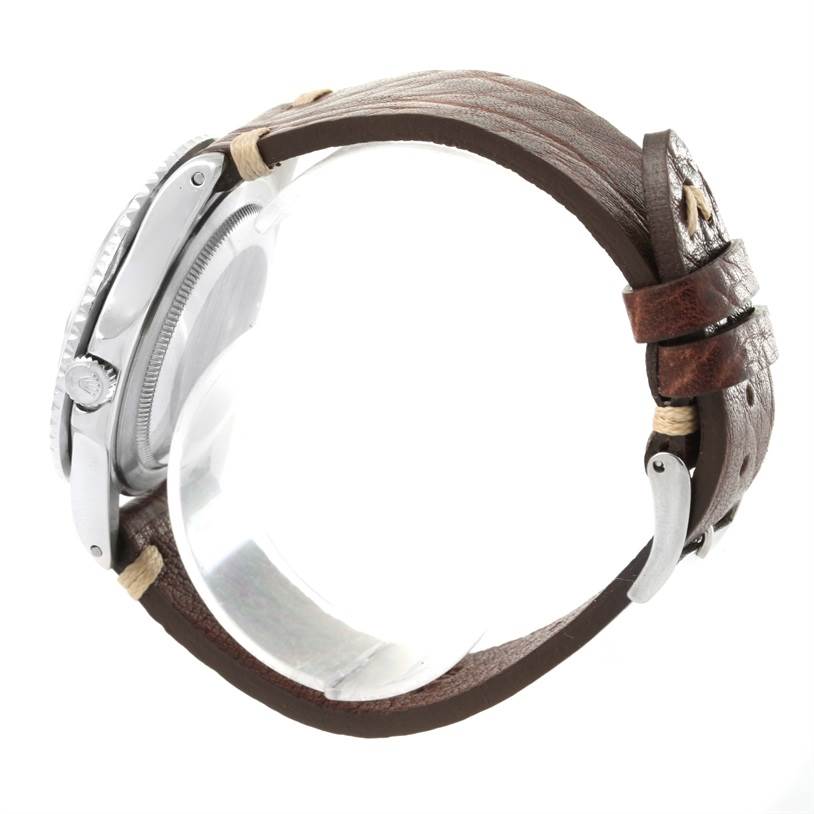 The image shows a side view of the Vintage Collection model by Rolex, highlighting the crown, case, and brown leather strap.