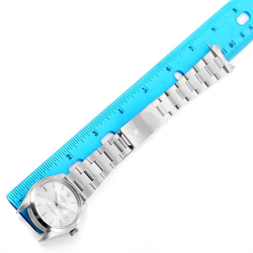 The Rolex Vintage Collection 1500 Men's Stainless Steel Silver Dial 1500 Men's Stainless Steel Silver Dial model watch is shown laid flat next to a ruler, displaying its face, bracelet, and clasp.