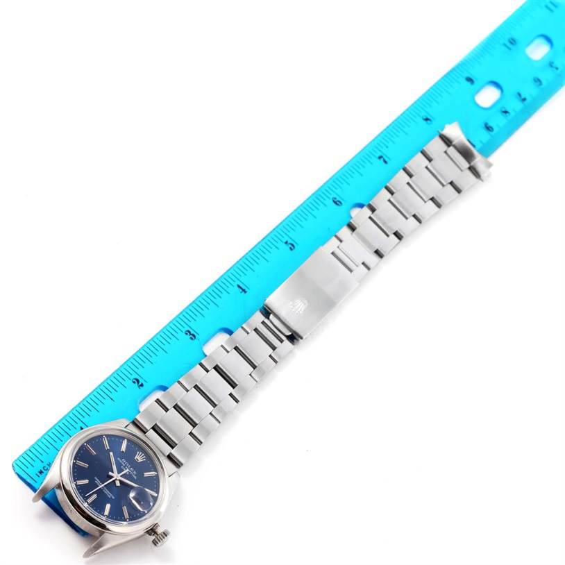 The image shows a top-down view of a Rolex Vintage Collection 1500 Men's Stainless Steel Blue Dial 1500 Men's Stainless Steel Blue Dial watch with a blue dial and the full stainless steel bracelet measured against a ruler.