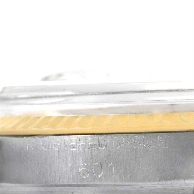The image shows a close-up of the side of a Rolex Vintage Collection 1601 Men's Stainless Steel Silver Dial 1601 Men's Stainless Steel Silver Dial watch, specifically the "Registered Design" and model number "1601" engraving.