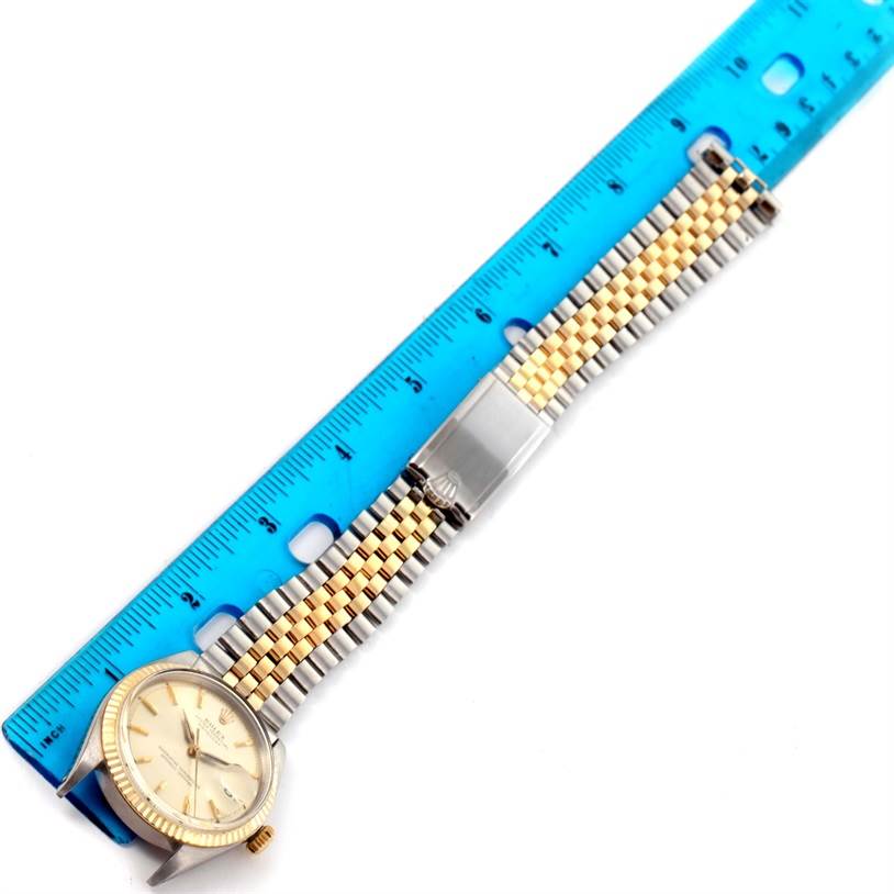 The Vintage Collection Rolex watch is shown with its band alongside a blue ruler for measurement.