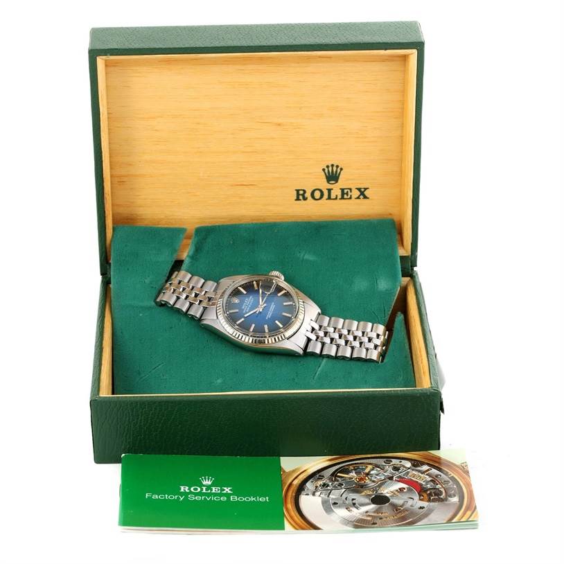 The image showcases a Rolex Vintage Collection 1601 Men's Stainless Steel Blue Dial 1601 Men's Stainless Steel Blue Dial model watch in its green box, along with a factory service booklet.