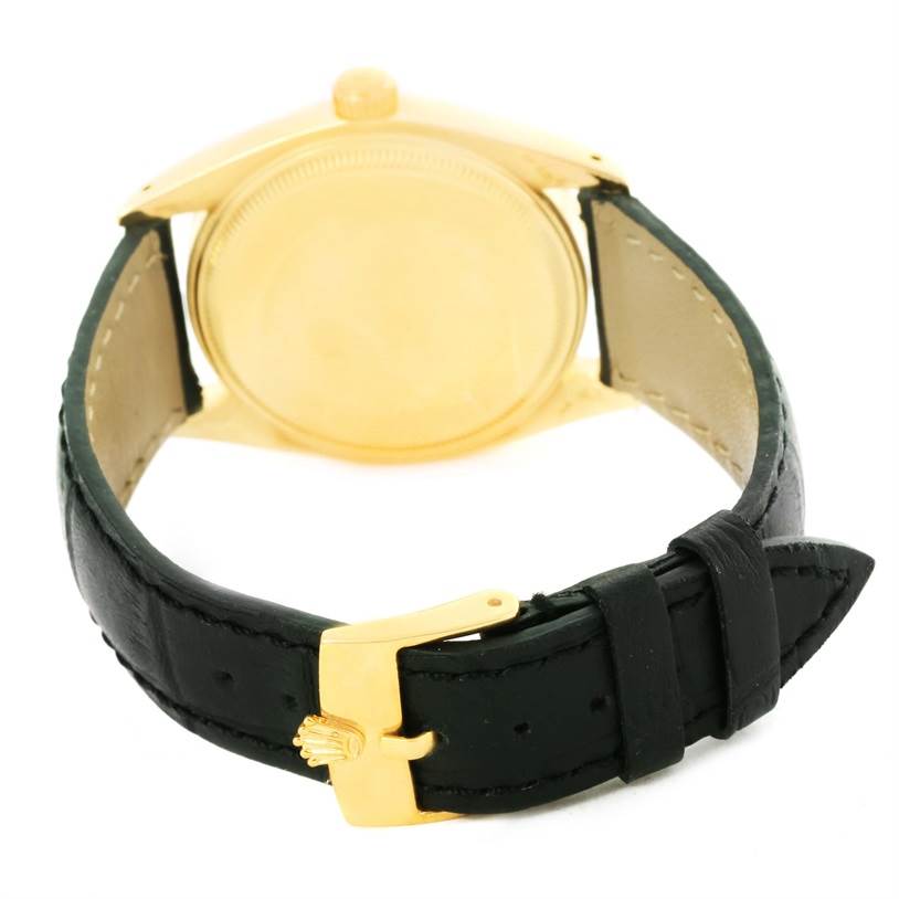 The image shows the back of the Rolex Vintage Collection 1503 Men's Yellow Gold Champagne Dial 1503 Men's Yellow Gold Champagne Dial watch, with emphasis on its gold-toned case and black leather strap with a Rolex gold buckle.