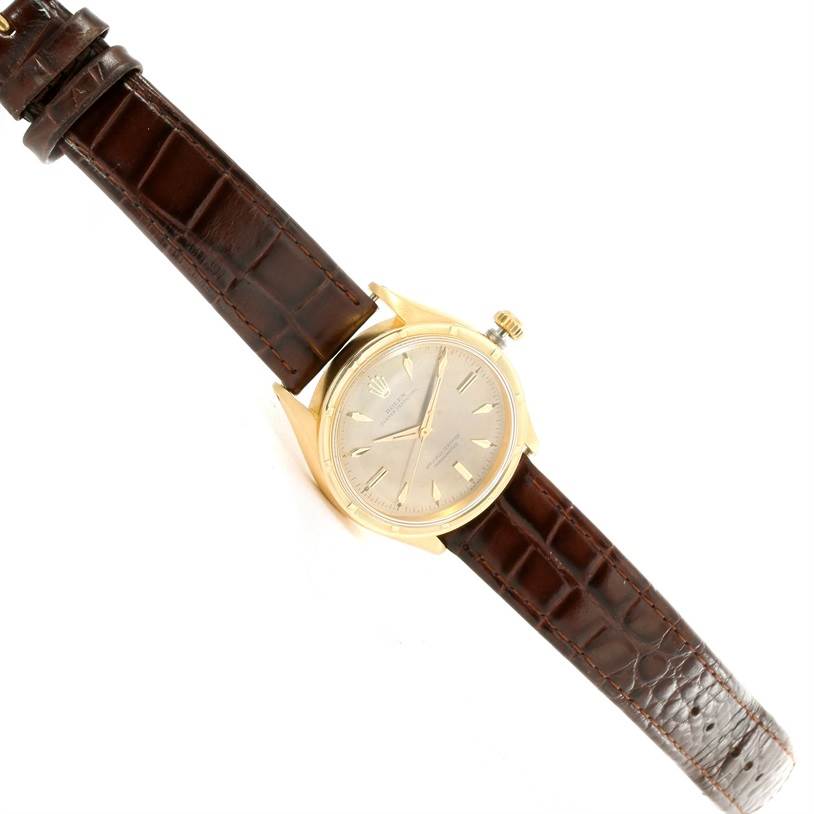 The Rolex Vintage Collection 6569 Men's Yellow Gold Brown Dial 6569 Men's Yellow Gold Brown Dial watch is shown from a top-down angle, displaying its dial, case, crown, and leather strap.