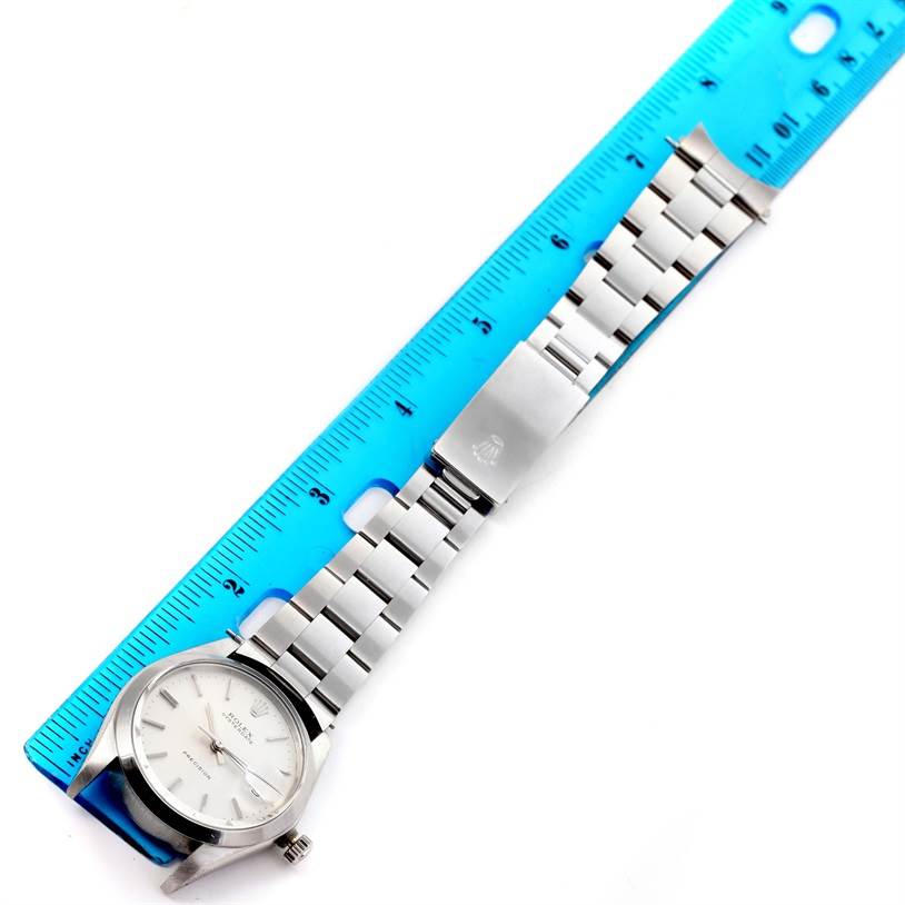 The Rolex Vintage Collection 6694 Men's Stainless Steel Silver Dial 6694 Men's Stainless Steel Silver Dial watch is shown from a top-down angle, displaying the face, bracelet, and clasp alongside a blue ruler for reference.