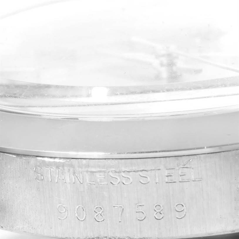 The image shows a close-up of the side view of a Rolex Vintage Collection 6694 Men's Stainless Steel Silver Dial 6694 Men's Stainless Steel Silver Dial watch, focusing on the serial number and "Stainless Steel" engraving.