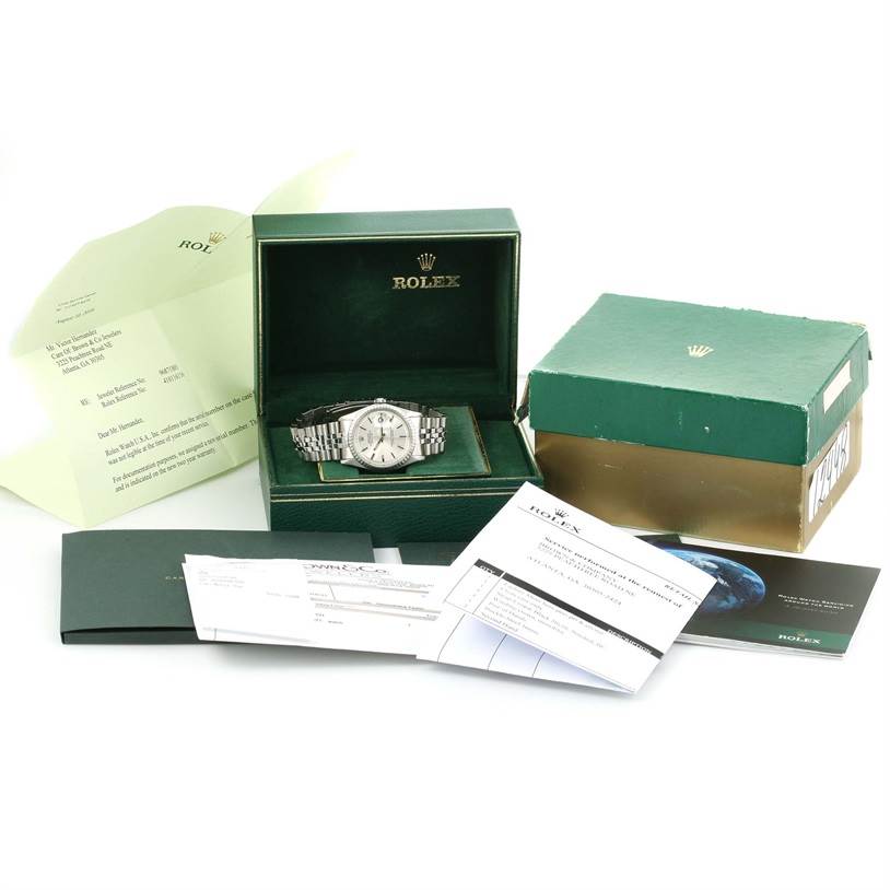 The image displays a Rolex Vintage Collection 1603 Men's Stainless Steel Silver Dial 1603 Men's Stainless Steel Silver Dial watch within its box, accompanied by various documents and packaging materials.
