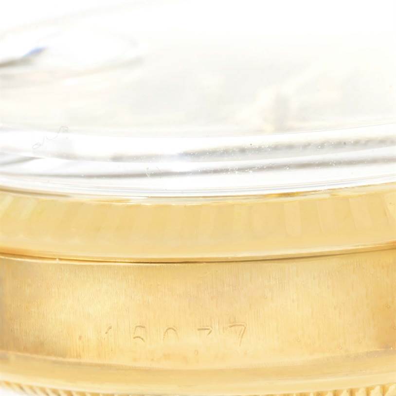 The image shows a close-up side view of a Rolex Vintage Collection 15037 Men's Yellow Gold Silver Dial 15037 Men's Yellow Gold Silver Dial watch, highlighting the bezel and part of the case with engravings.