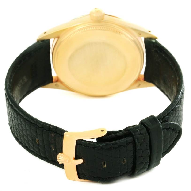 The image shows the back angle of the Vintage Collection model by Rolex, featuring the case back and leather strap with a buckle.