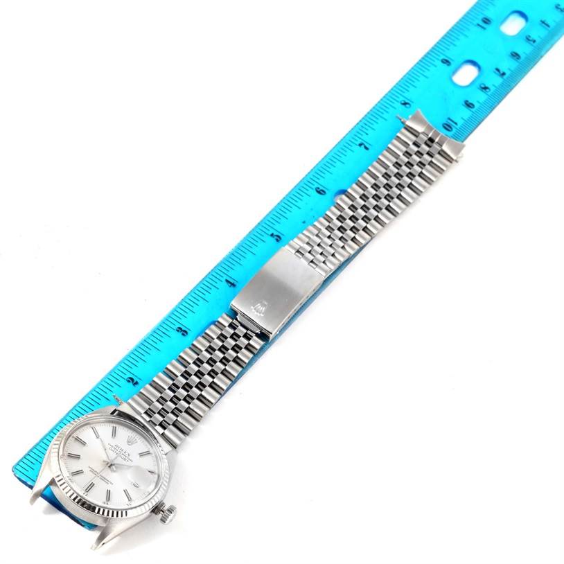 This image shows a Vintage Collection Rolex watch with a silver dial and metal link bracelet, laid flat next to a blue ruler.