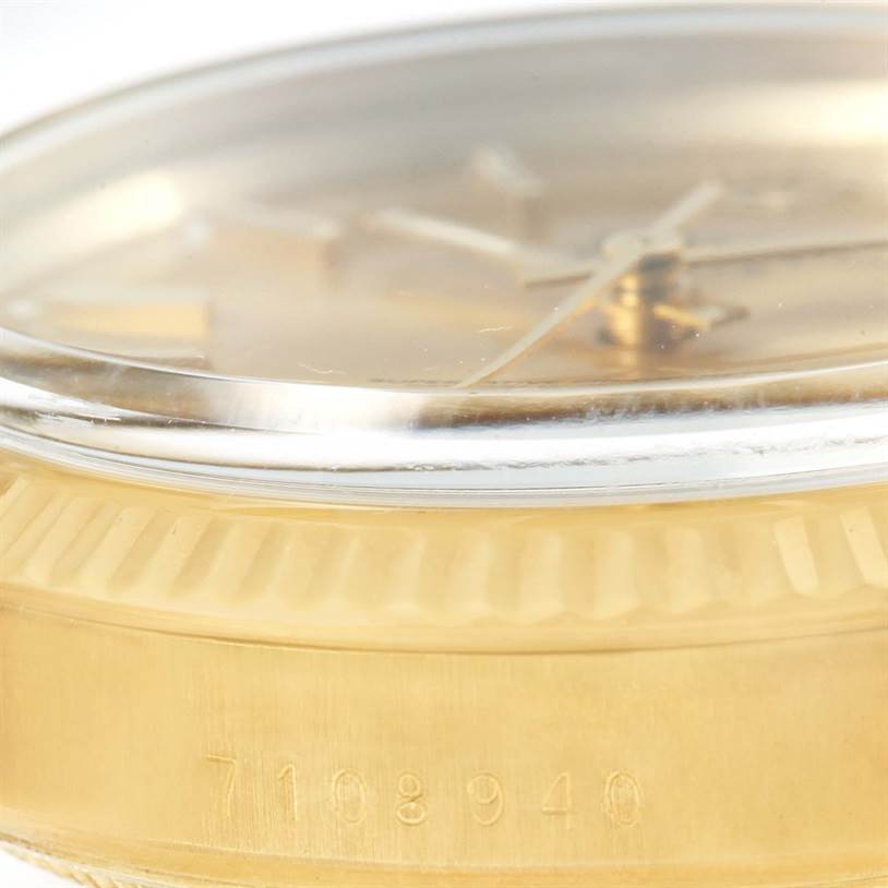 The image shows a side view of the Rolex Vintage Collection 15037 Men's Yellow Gold Champagne Dial 15037 Men's Yellow Gold Champagne Dial watch, highlighting its clear crystal, bezel, and engraved serial number.