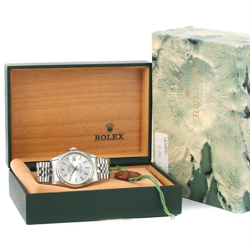 This image shows a Vintage Collection Rolex watch resting inside its open wooden box, alongside the outer packaging and a tag.