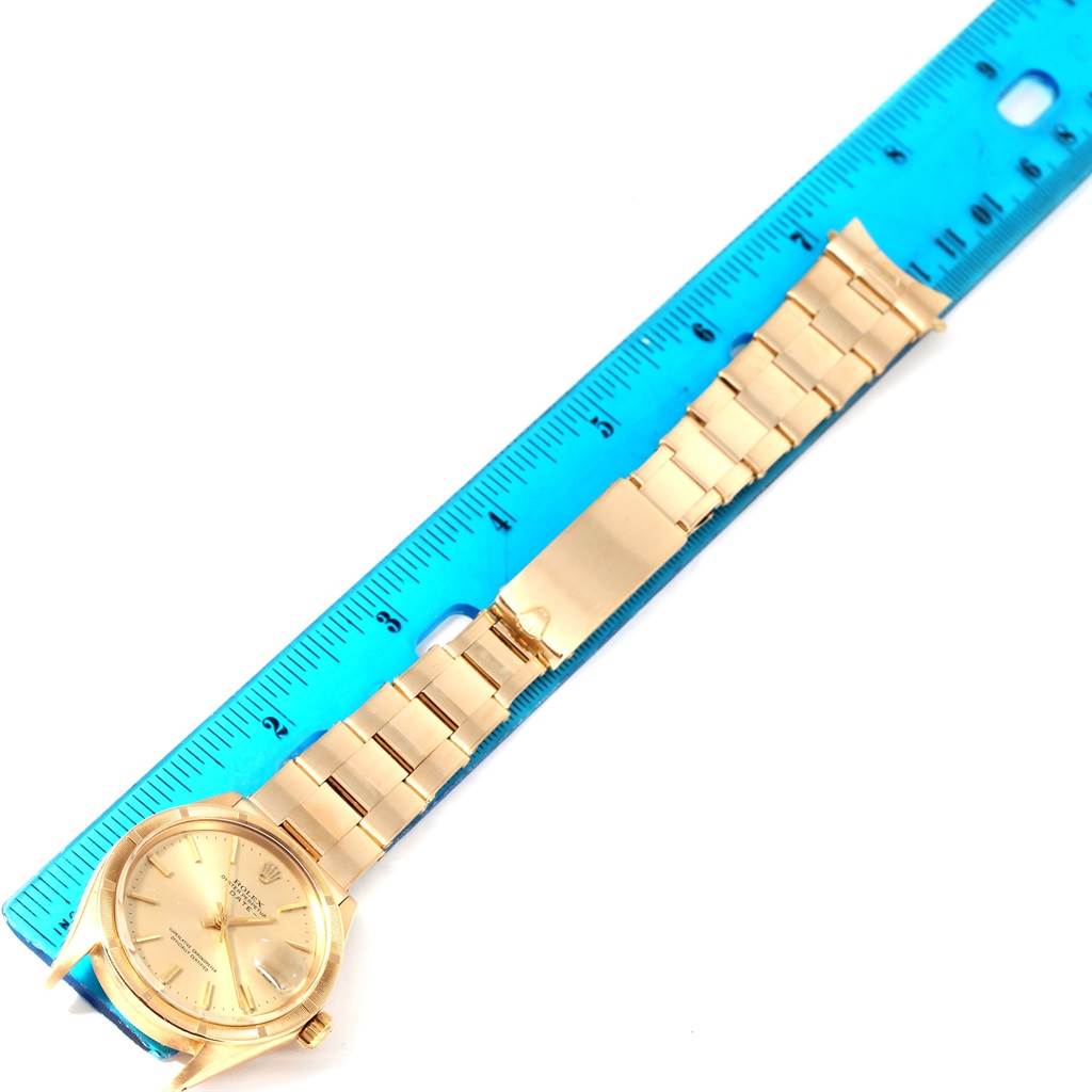 The image shows a top-down view of the Rolex Vintage Collection 1500 Men's Yellow Gold Champagne Dial 1500 Men's Yellow Gold Champagne Dial watch, including its face and band next to a ruler.