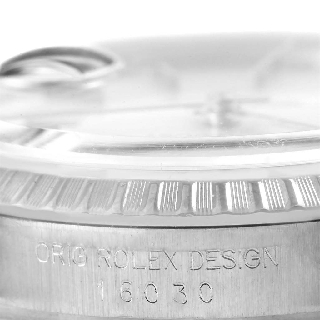This close-up of the Rolex Vintage Collection 16030 Men's Stainless Steel Silver Dial 16030 Men's Stainless Steel Silver Dial model shows the fluted bezel and the engraved casing design and model number.