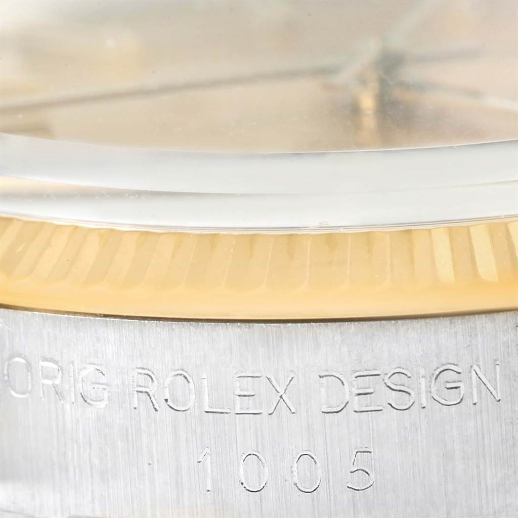 This close-up shot shows the side view of the bezel and case of a Rolex Vintage Collection 1005 Men's Steel and Gold (two tone) Champagne Dial 1005 Men's Steel and Gold (two tone) Champagne Dial model, featuring the engraved model number.