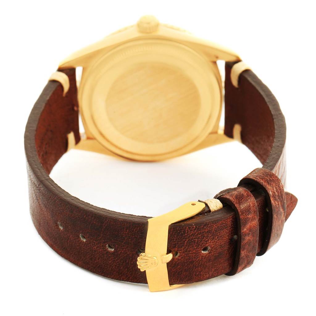 The image shows the back view of a Rolex Vintage Collection 1625 Men's Yellow Gold Champagne Dial 1625 Men's Yellow Gold Champagne Dial watch with a leather strap and gold clasp.