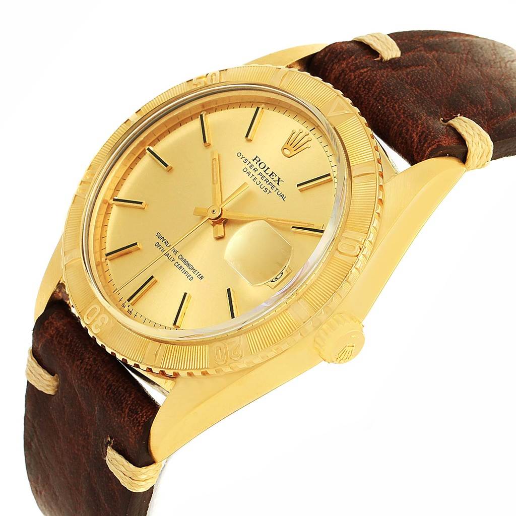 This image shows a close-up angle of a Rolex Vintage Collection 1625 Men's Yellow Gold Champagne Dial 1625 Men's Yellow Gold Champagne Dial model watch, highlighting the gold dial, bezel, and leather strap.