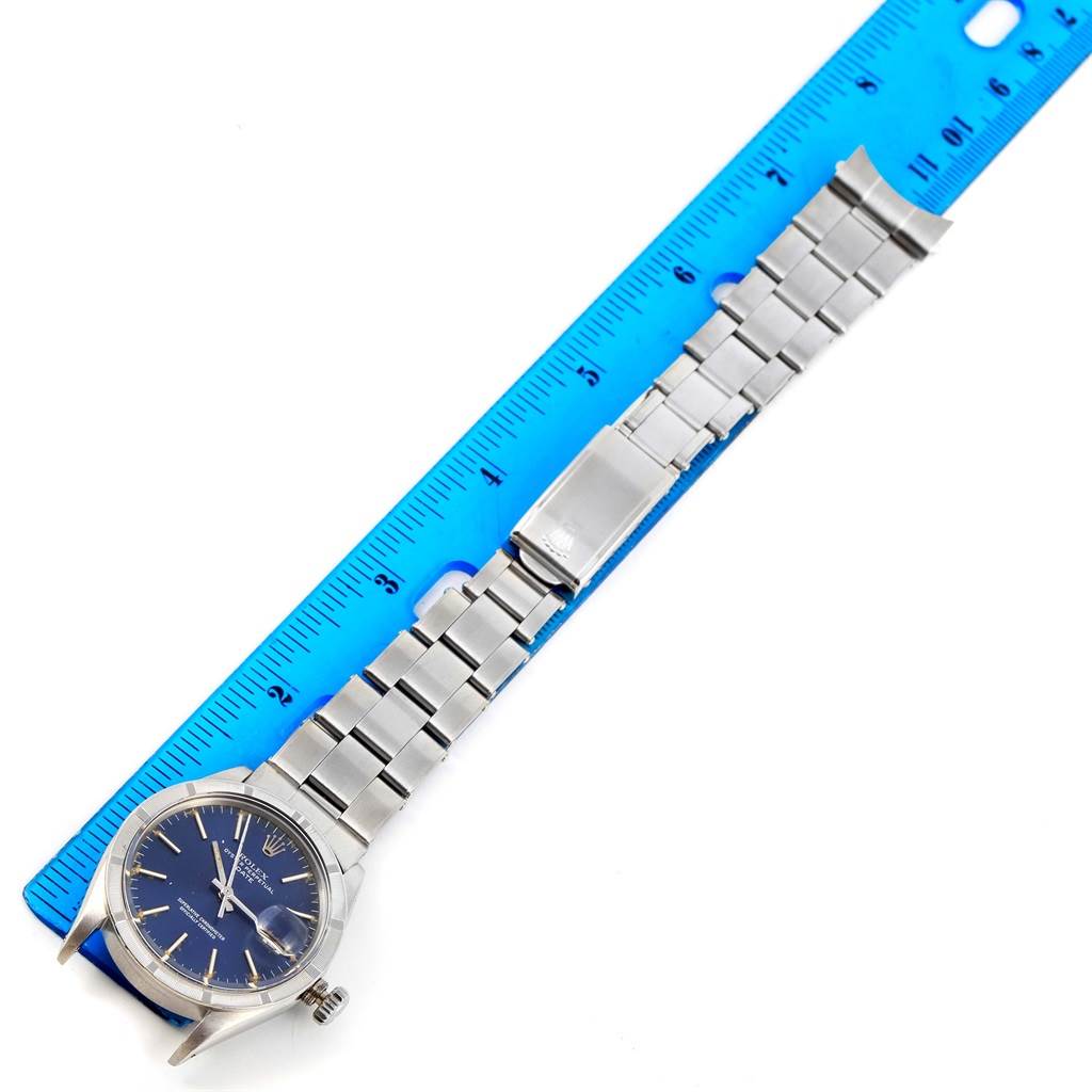 The Rolex Vintage Collection 1501 Men's Stainless Steel Blue Dial 1501 Men's Stainless Steel Blue Dial model is shown from a top-down angle, displaying its face, bracelet, and part of a clasp alongside a ruler for scale.