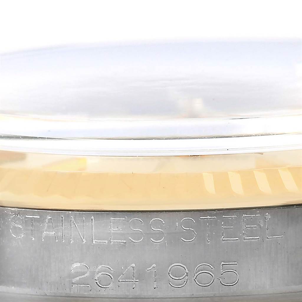 The image shows a close-up of the side view of a Vintage Collection Rolex watch, highlighting the stainless steel engraving and serial number.