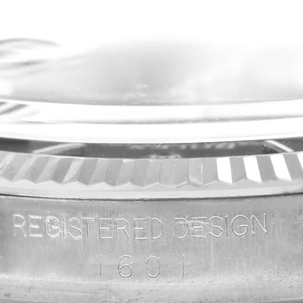 The image shows a close-up view of the side of the Rolex Vintage Collection 1601 Men's Stainless Steel Black Dial 1601 Men's Stainless Steel Black Dial watch model 1601, highlighting its bezel and "Registered Design" engraving.