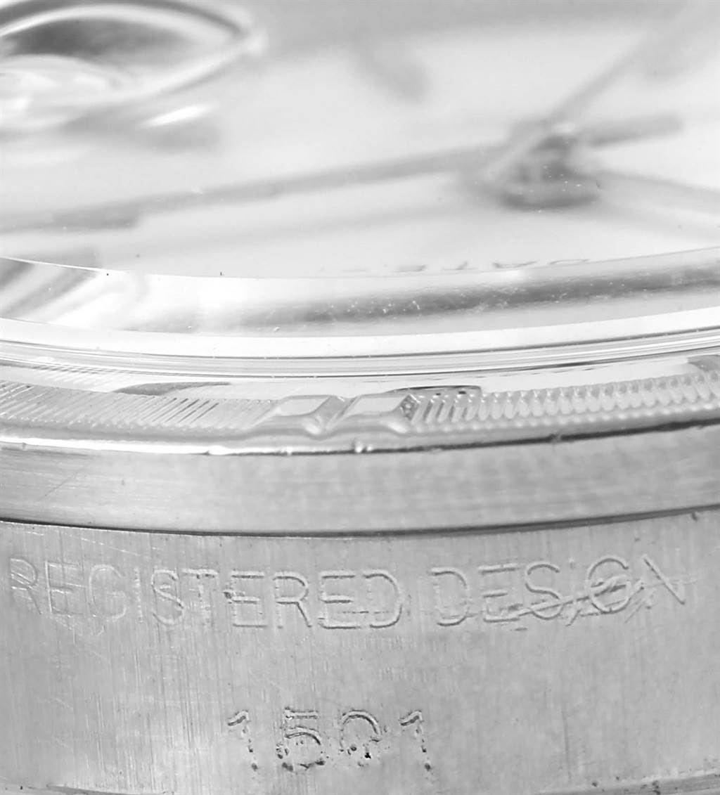 This close-up image of the Rolex Vintage Collection 1501 Men's Stainless Steel White Dial 1501 Men's Stainless Steel White Dial watch shows its bezel, case, and part of the crystal with engraved text.