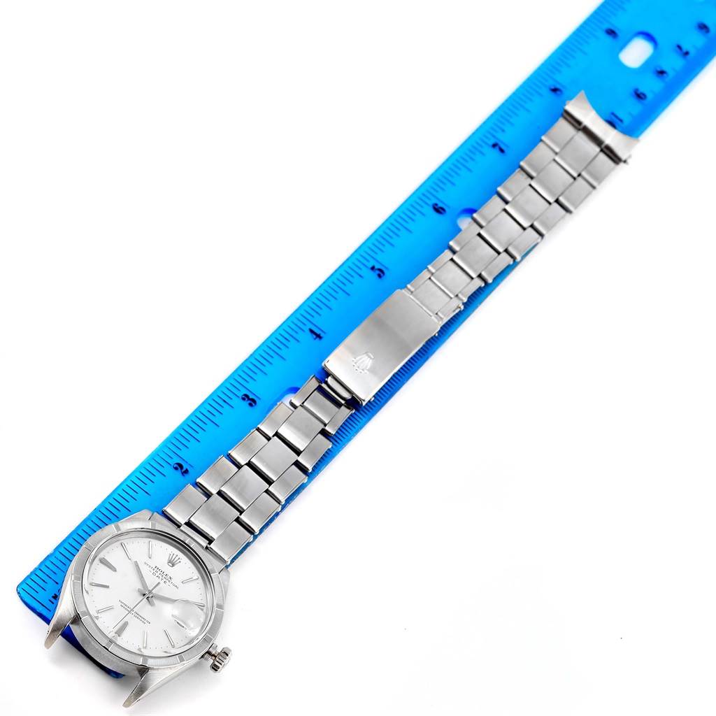 The image shows a Rolex Vintage Collection 1501 Men's Stainless Steel White Dial 1501 Men's Stainless Steel White Dial watch laid flat next to a blue ruler, displaying its band and watch face.