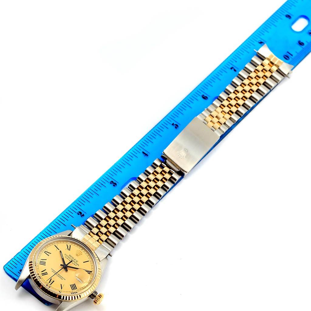 The Rolex Vintage Collection 16013 Men's Stainless Steel Champagne Dial 16013 Men's Stainless Steel Champagne Dial watch is shown from a top-down angle, highlighting its face, band, and clasp, with a ruler for scale.