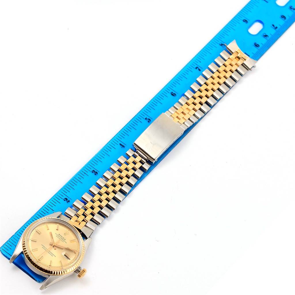 This image shows a top view of a Rolex Vintage Collection 1601 Men's Stainless Steel Champagne Dial 1601 Men's Stainless Steel Champagne Dial watch, focusing on the face, bezel, and two-tone bracelet next to a ruler.