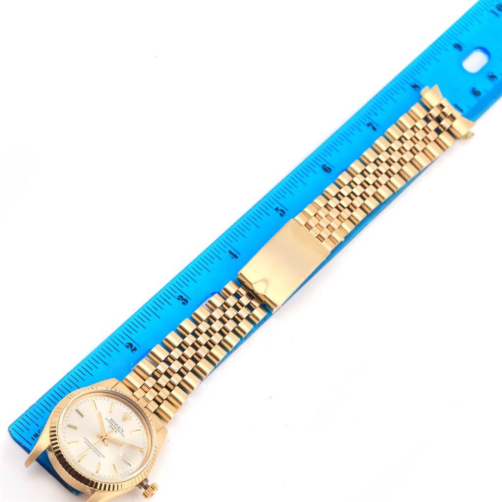 The image shows a Rolex Vintage Collection 15037 Men's Yellow Gold Silver Dial 15037 Men's Yellow Gold Silver Dial watch with its face and bracelet fully extended, placed next to a blue ruler for scale.