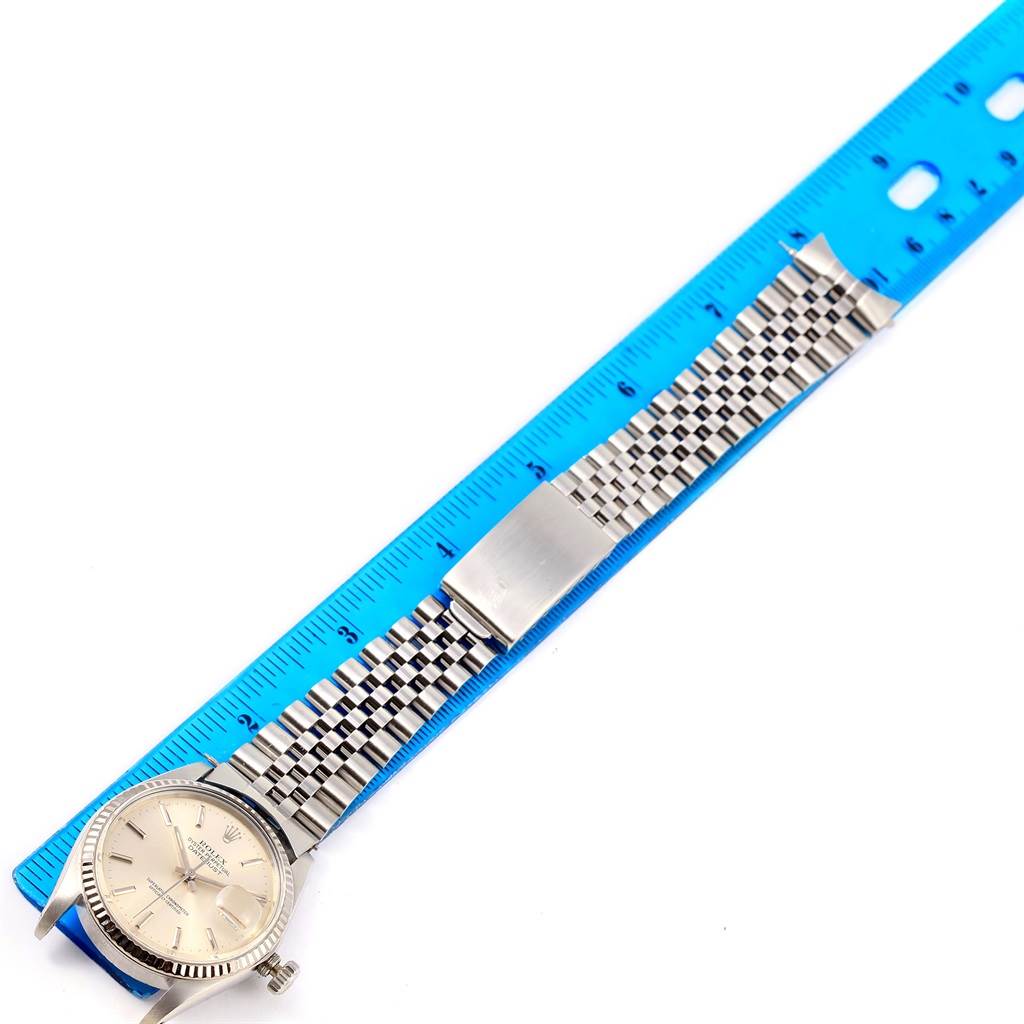 The image shows a Rolex Vintage Collection 16014 Men's Stainless Steel Silver Dial 16014 Men's Stainless Steel Silver Dial watch laid flat next to a blue ruler, showcasing its face and bracelet.