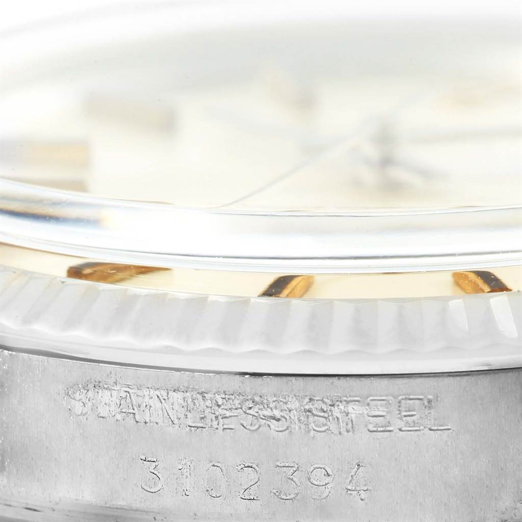 Close-up side angle of a Vintage Collection Rolex watch, showing part of the dial, bezel, and stainless steel case with serial number.