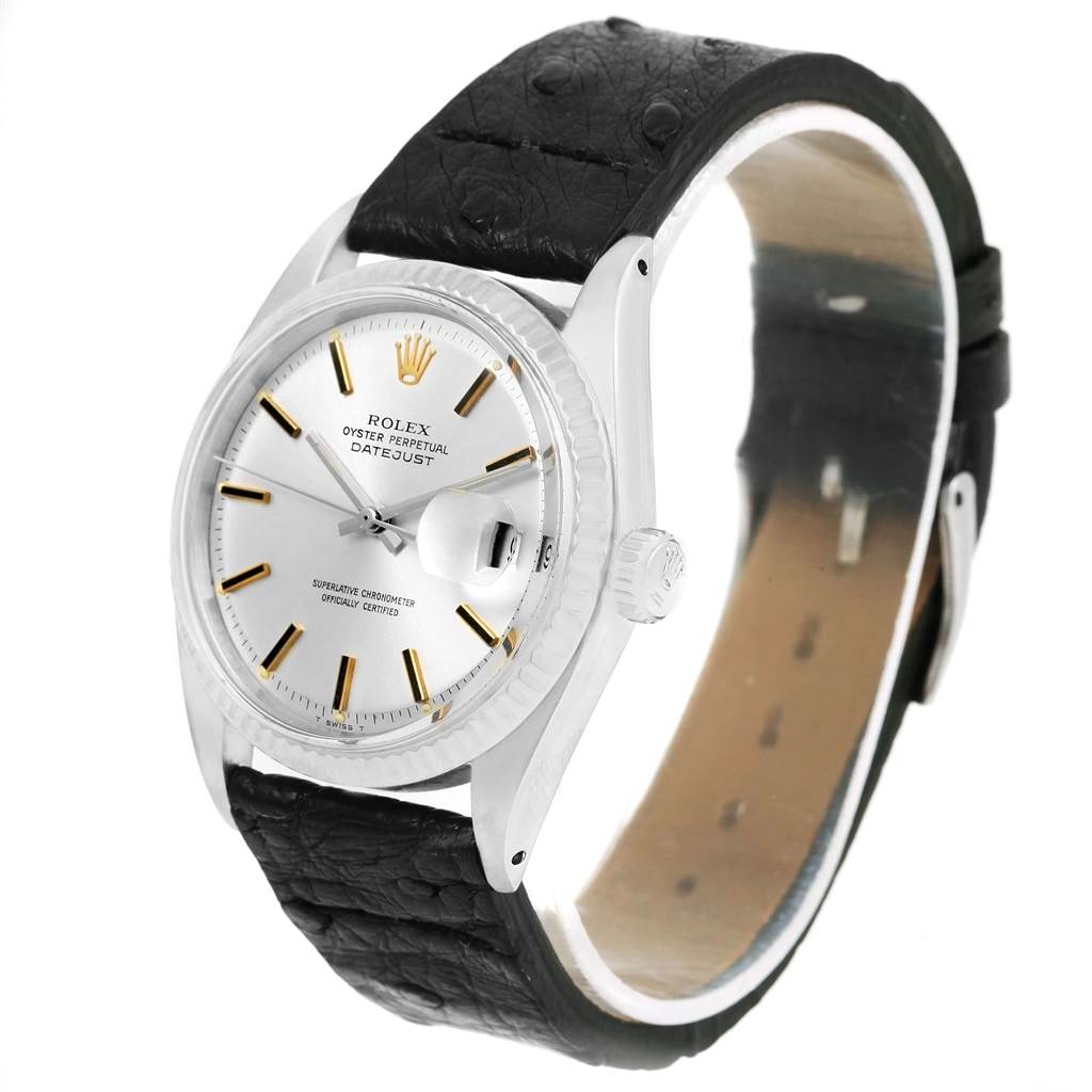 This image shows a Rolex Vintage Collection 1601 Men's Stainless Steel Black Dial 1601 Men's Stainless Steel Black Dial Datejust watch at a high-angle view, highlighting its dial, bezel, and leather strap.