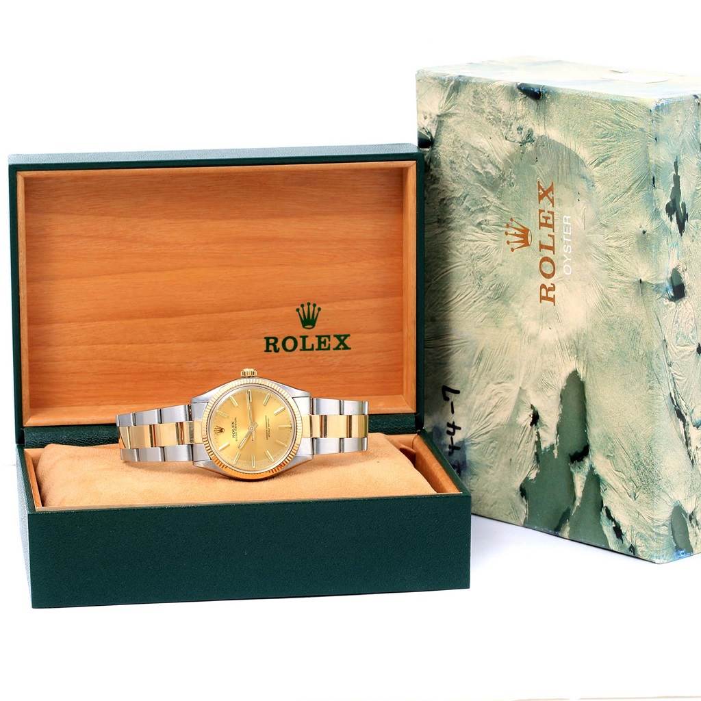 The Rolex Vintage Collection 1005 Men's Steel and Gold (two tone) Champagne Dial 1005 Men's Steel and Gold (two tone) Champagne Dial watch is shown inside an open green and wooden box, with the outer box featuring a marbled design.