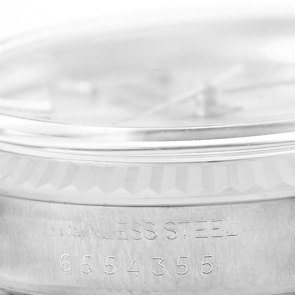 The image shows a close-up of the serial number and the phrase "STAINLESS STEEL" engraved on the side of the Rolex Vintage Collection 16014 Men's Stainless Steel Silver Dial 16014 Men's Stainless Steel Silver Dial watch case.