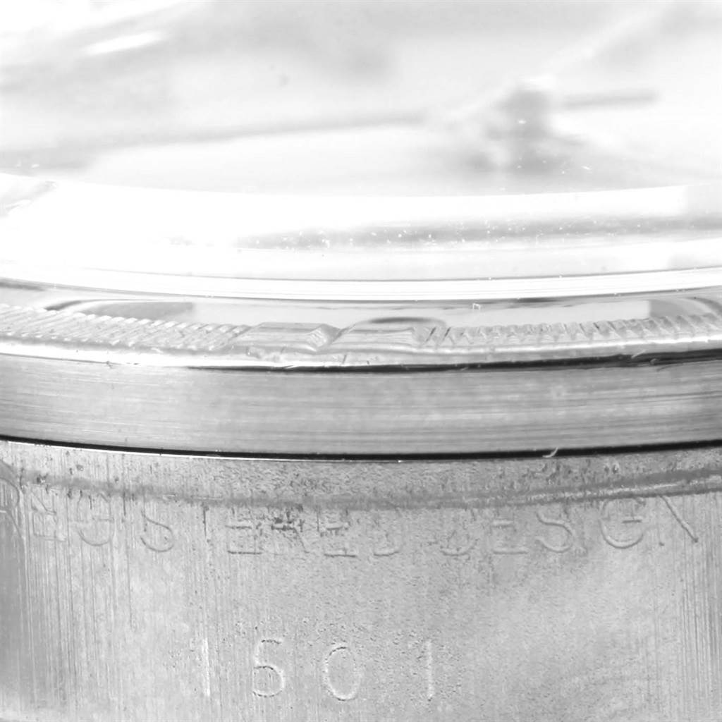 This close-up side view of a Rolex Vintage Collection 1501 Men's Stainless Steel Silver Dial 1501 Men's Stainless Steel Silver Dial watch shows the bezel and part of the case with the model number 1601 engraved.