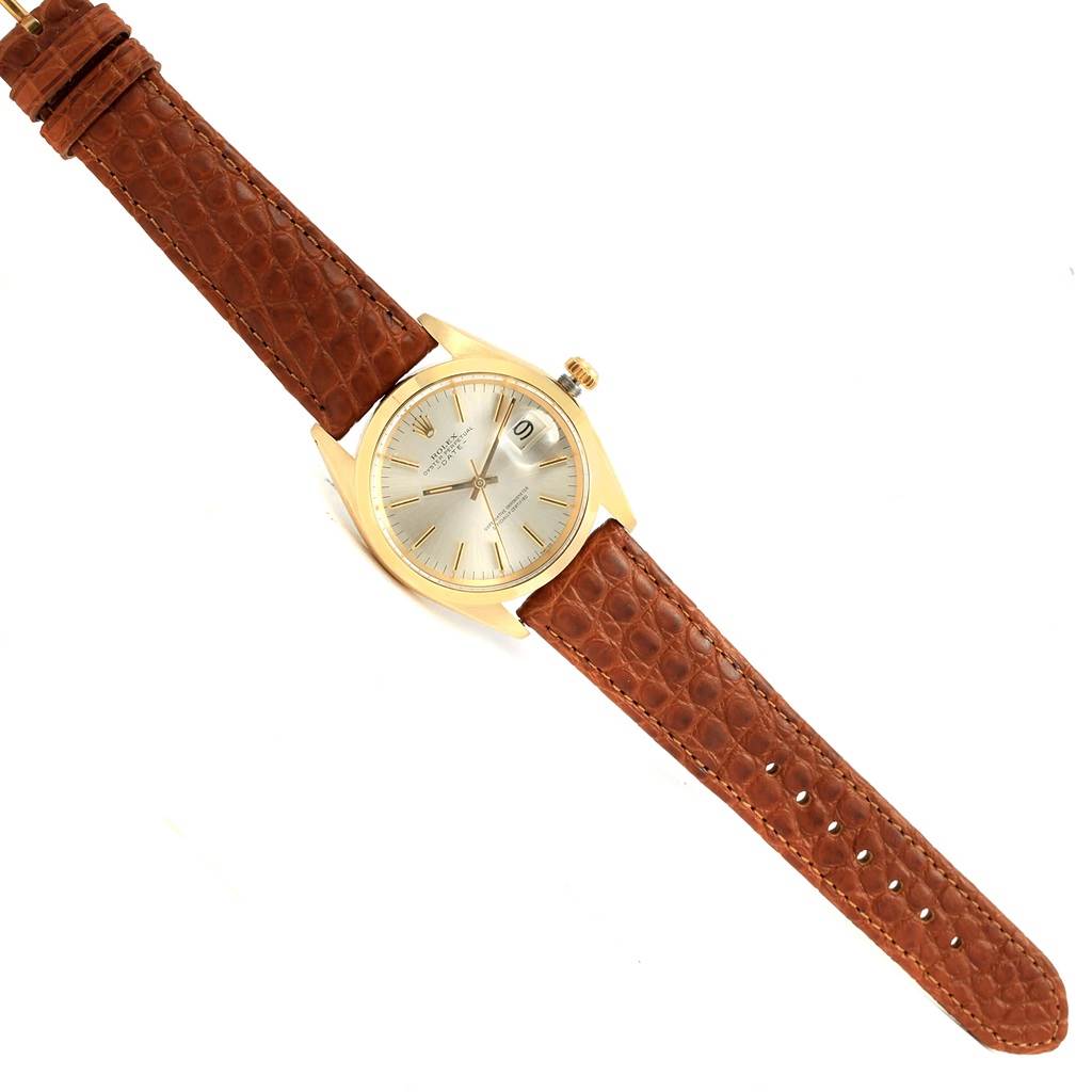 The image shows a top-down view of a Rolex Vintage Collection 1500 Men's Yellow Gold Champagne Dial 1500 Men's Yellow Gold Champagne Dial watch with a brown leather strap and a gold case.