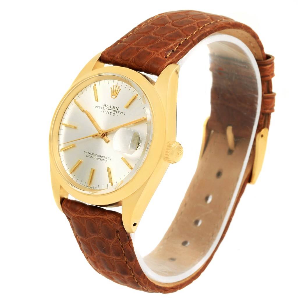 The Vintage Collection model by Rolex is shown at an angled view, featuring a gold case, white dial, brown leather strap, and date window.