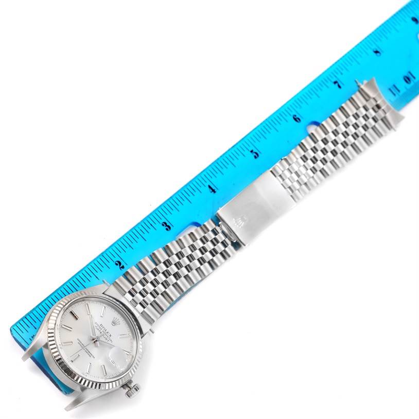 The image shows a Rolex Vintage Collection 16014 Men's Stainless Steel Silver Dial 16014 Men's Stainless Steel Silver Dial watch with its entire face, bracelet, and clasp, aligned alongside a blue ruler for measurement.