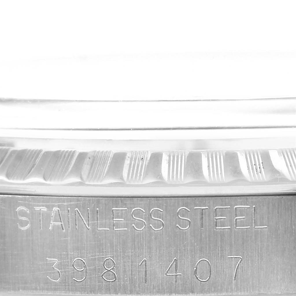 The image shows a close-up of the side view of a Rolex Vintage Collection 1603 Men's Stainless Steel Silver Dial 1603 Men's Stainless Steel Silver Dial watch, highlighting the stainless steel casing and serial number.