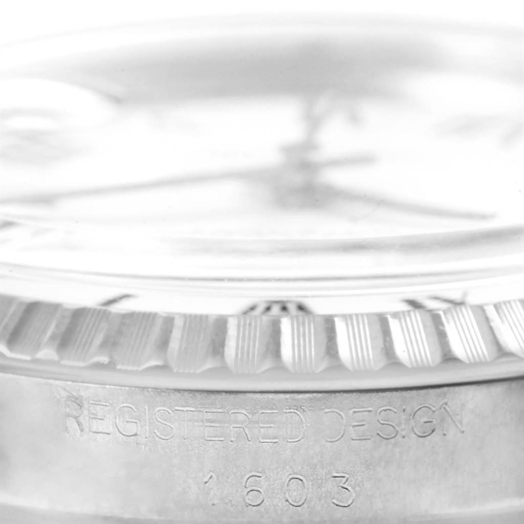 This close-up image of the Rolex Vintage Collection 1603 Men's Stainless Steel White Dial 1603 Men's Stainless Steel White Dial model shows the side of the watch case, including part of the bezel with "REGISTERED DESIGN 1603" engraving.