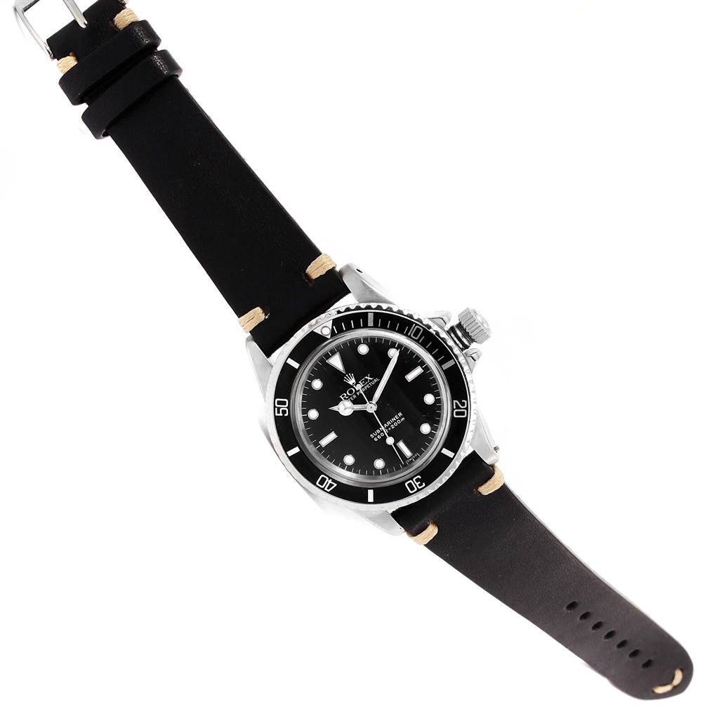 The Vintage Collection Rolex watch is shown at an oblique angle, highlighting its face, bezel, crown, and leather strap.