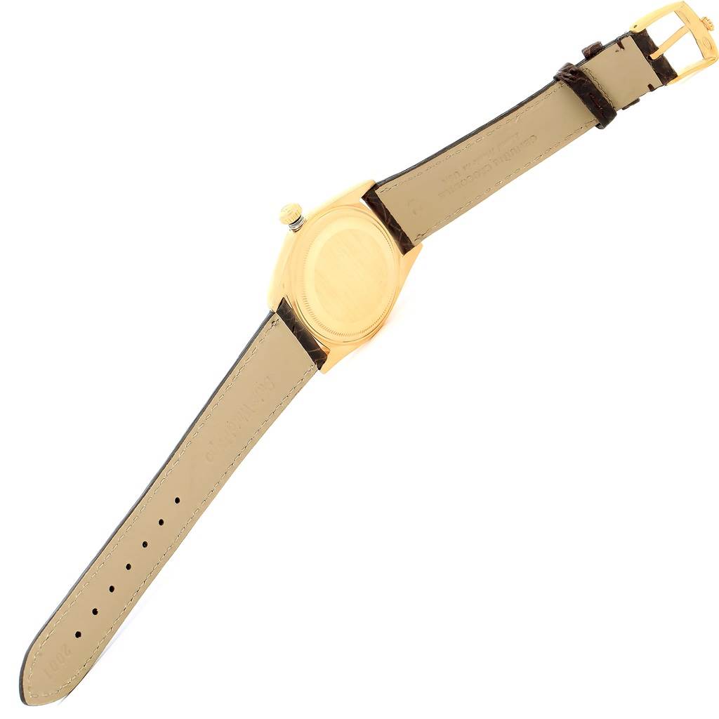 This image shows the back and leather strap of a Rolex Vintage Collection 1601 Men's Yellow Gold Champagne Dial 1601 Men's Yellow Gold Champagne Dial watch laid flat at an angle.