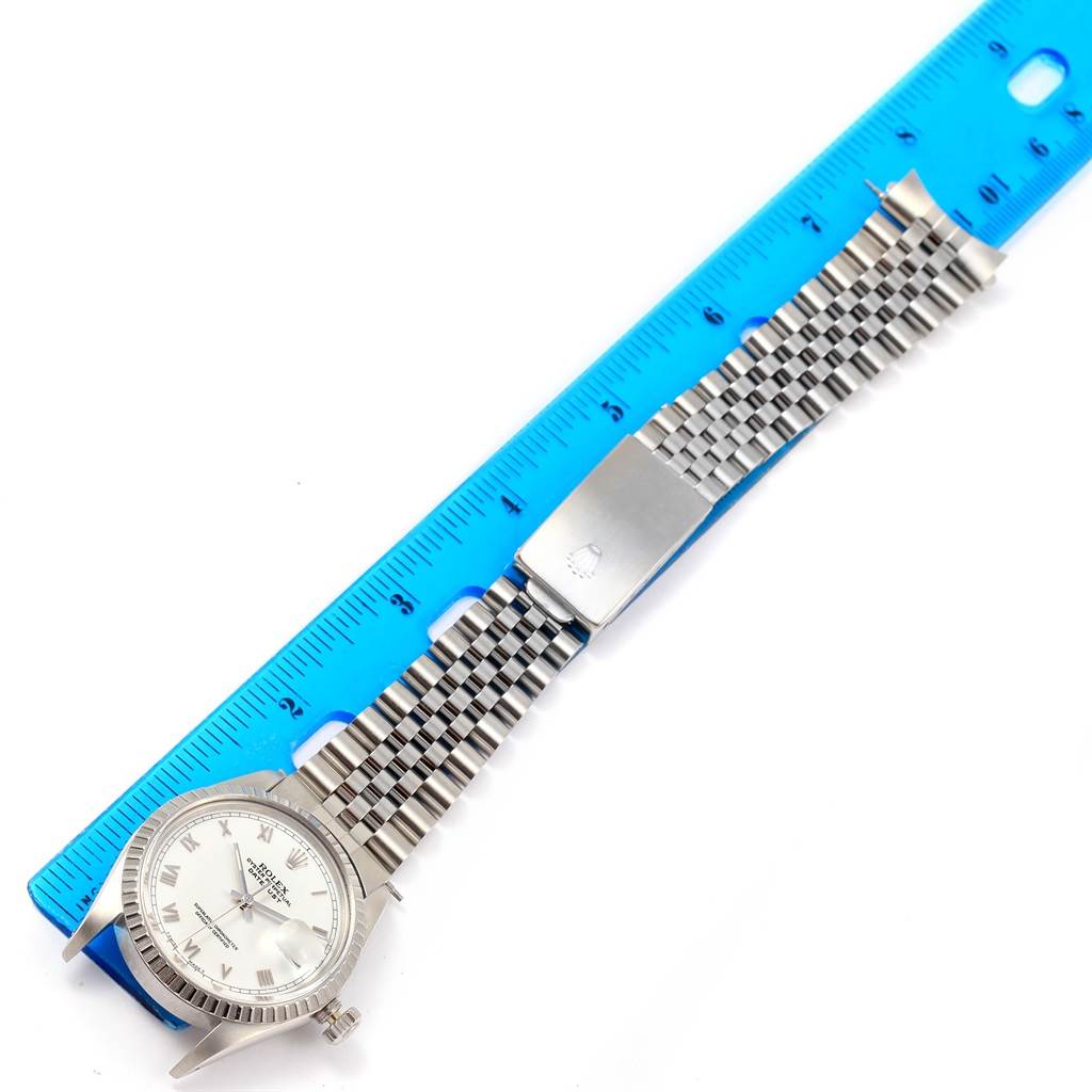 The image shows a full, top-down view of a Rolex Vintage Collection 16030 Men's Stainless Steel Silver Dial 16030 Men's Stainless Steel Silver Dial watch with a metallic band and clasp, placed next to a blue ruler.