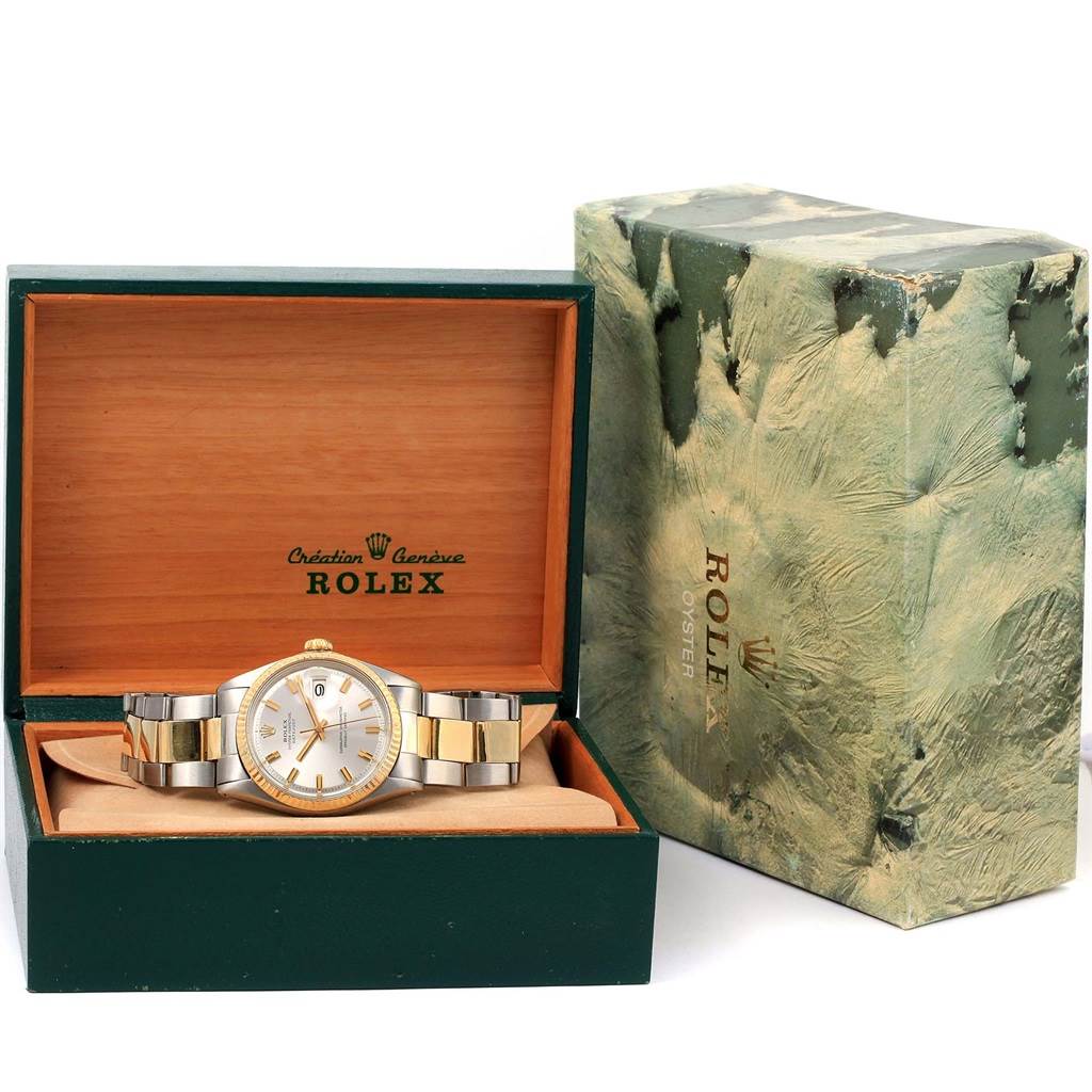 The photo shows a Rolex Vintage Collection 1601 Men's Stainless Steel Silver Dial 1601 Men's Stainless Steel Silver Dial watch placed in an open green Rolex box with a branded outer covering beside it.