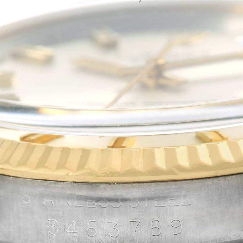 This close-up angle of the Vintage Collection Rolex watch displays the dial, hands, gold bezel, and part of the stainless steel casing with serial number.